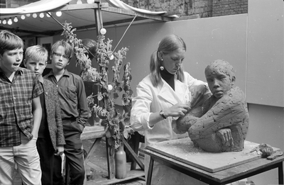 120214 Portret van beeldhouwster Annet van den Acker - Haring op de kunstmarkt op het Janskerkhof te Utrecht.